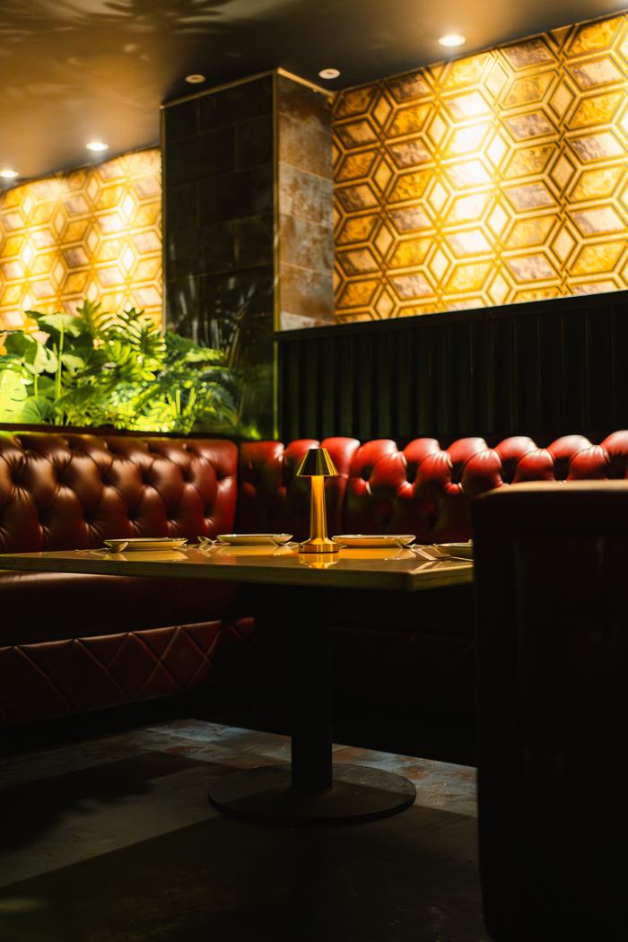 A corner booth at Bellers against the gold wall