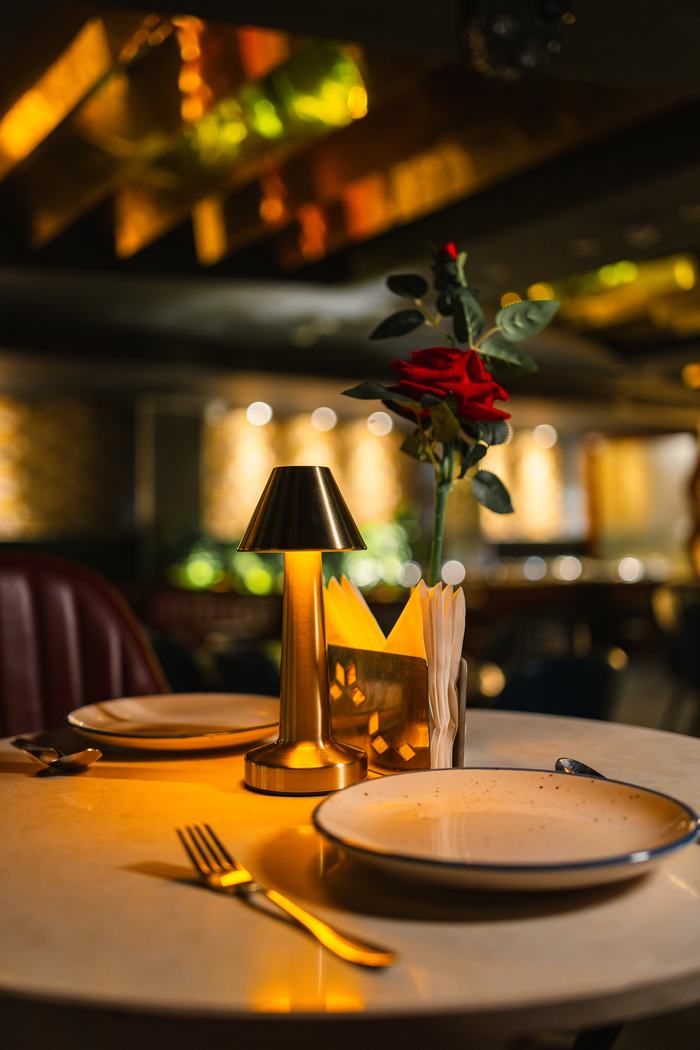 A table laid at Bellers, rose and lamp