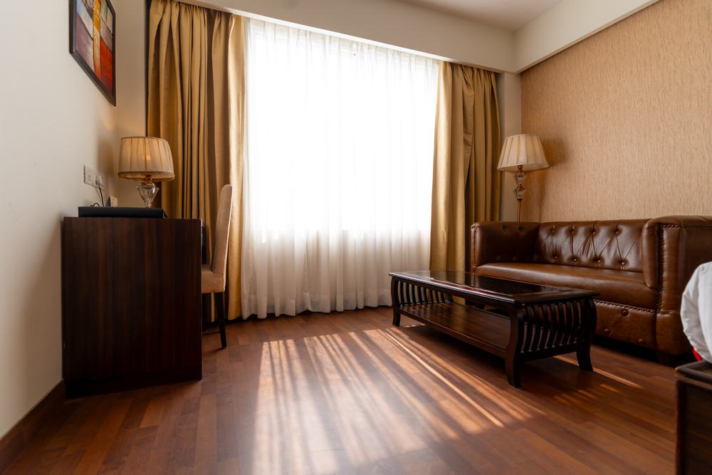 The sitting area of an Executive Room, daylight through full-height curtains