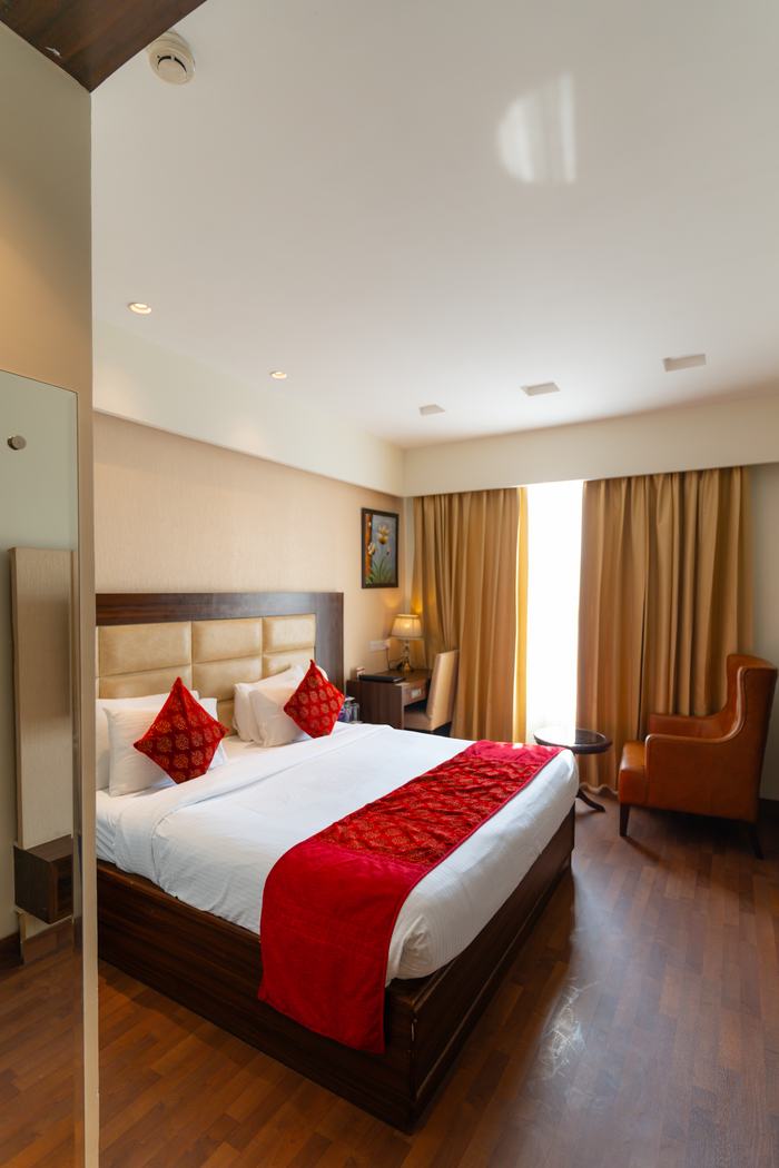 An Executive Room, king bed and armchair on walnut flooring