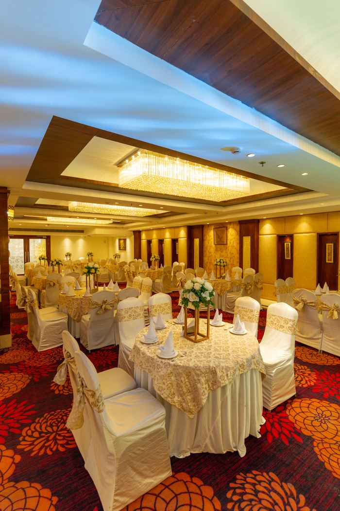 Rounds dressed in cream and gold under the chandeliers, the hall ready