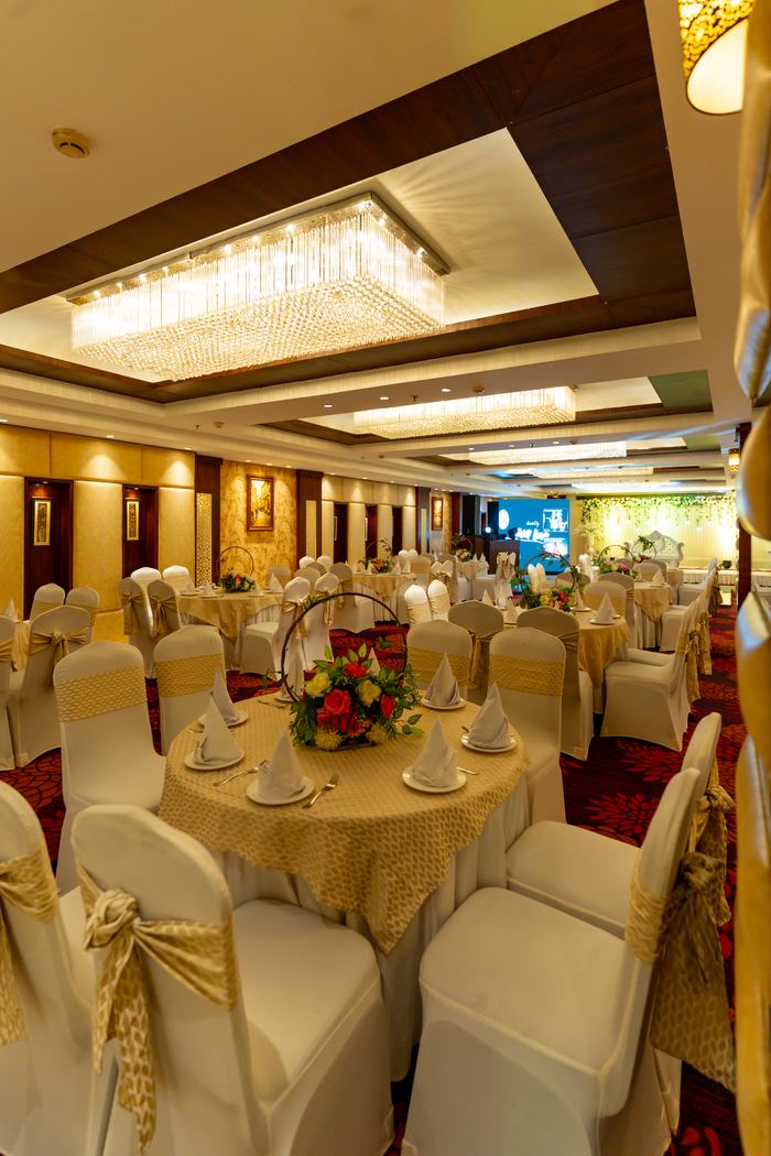 The hall laid in cream and gold under the chandeliers