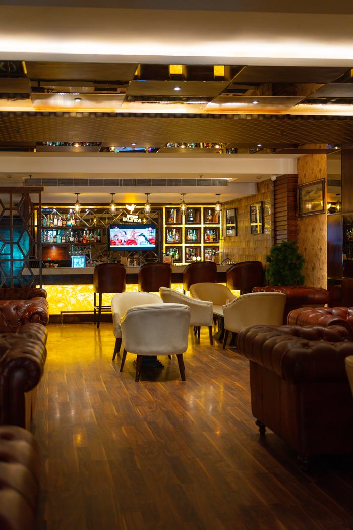 The lounge, buttoned leather sofas under backlit display cases