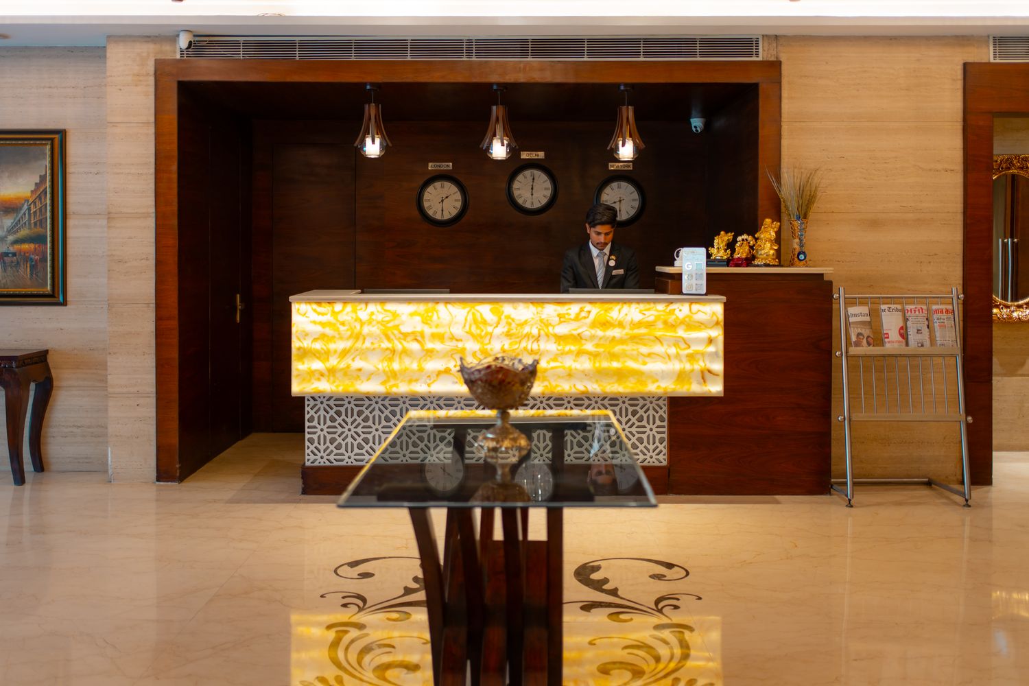 The reception desk, its backlit onyx counter and the three world clocks