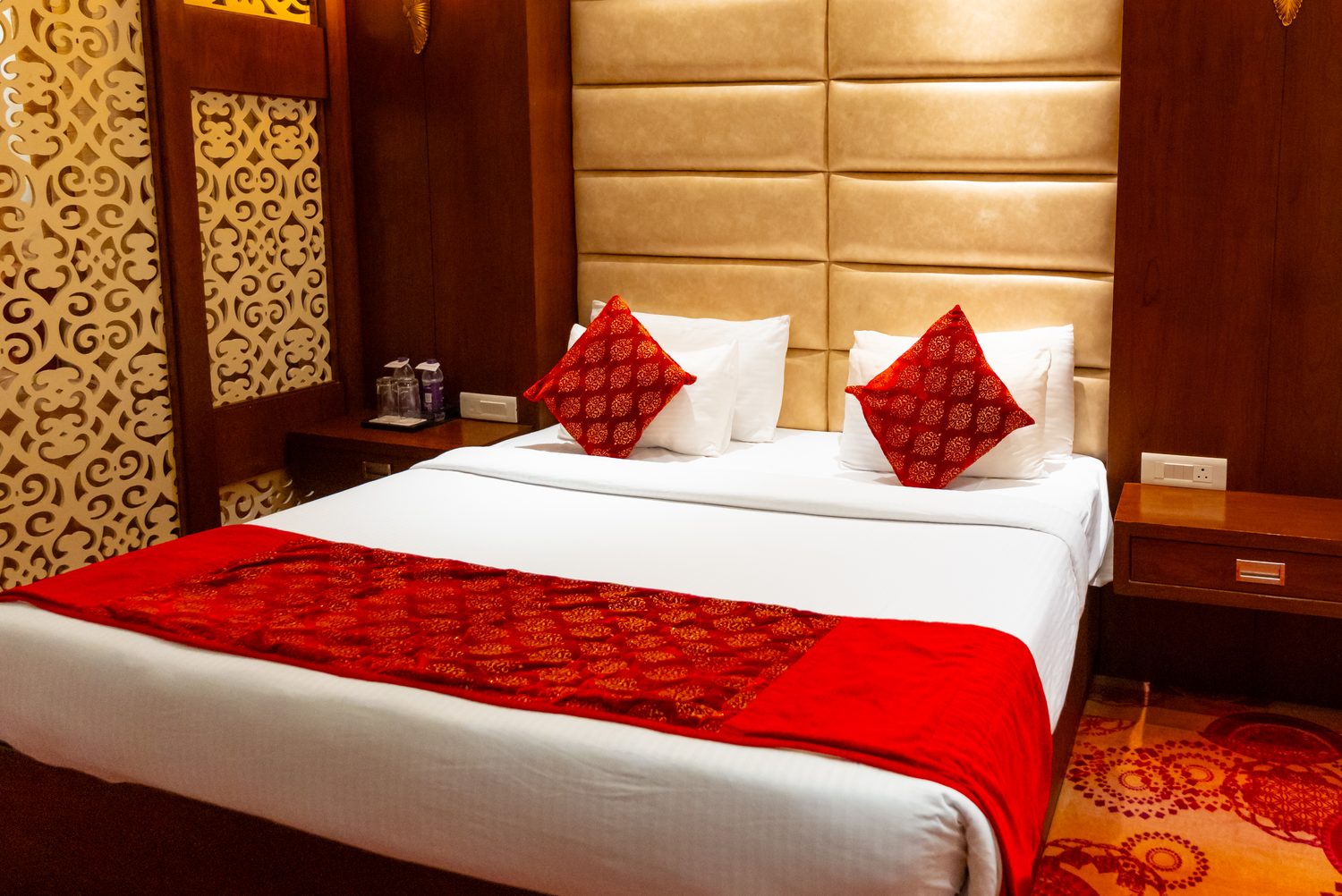 A Suite bedroom, patterned carpet and quilted headboard