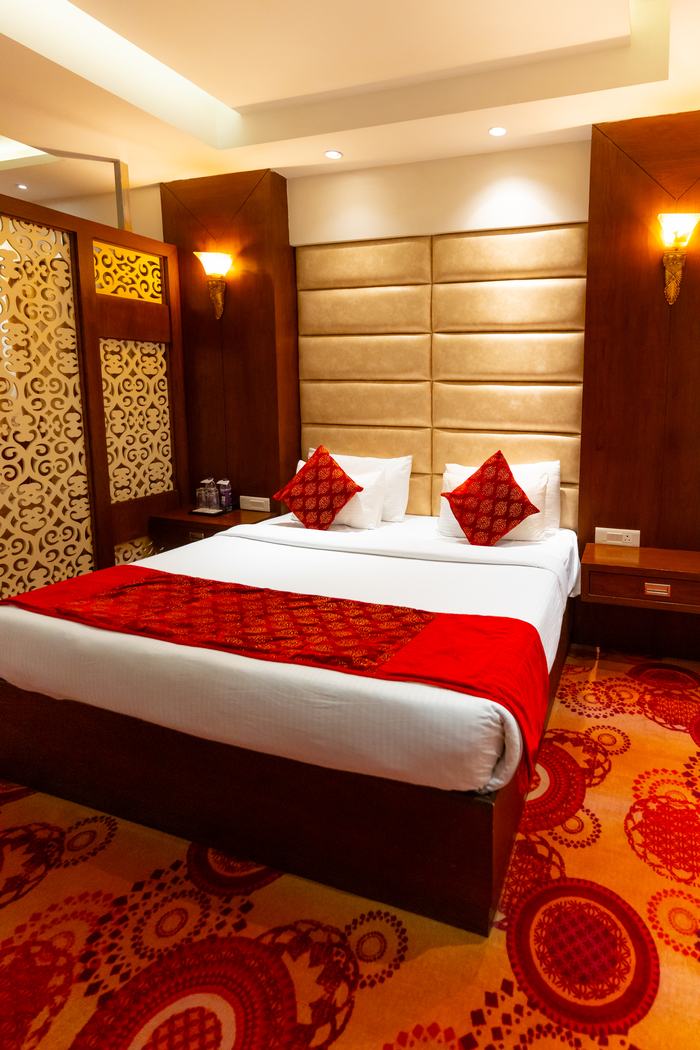 A Suite bedroom, patterned carpet and quilted headboard
