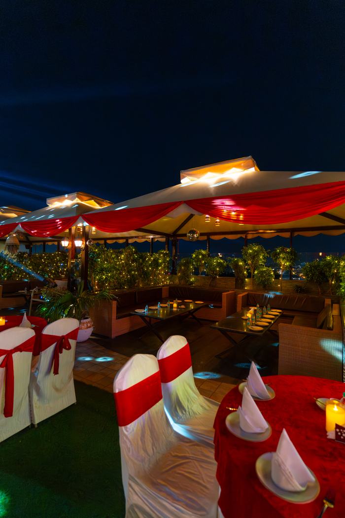 The terrace under its umbrellas after dark